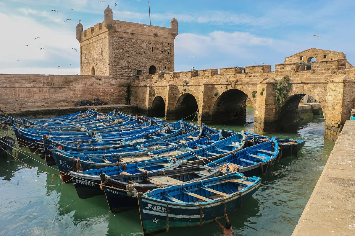 Blue fishing boats beside Essaouira’s fortified harbour